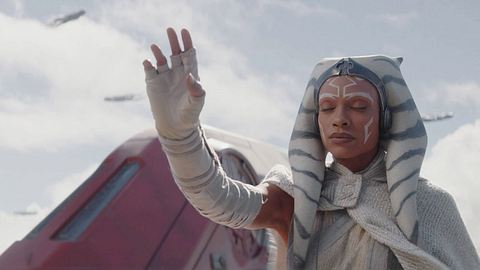 Ahsoka Tona hebt mit geschlossenen Augen die Hand. Sie trägt ein weißes Gewand. Im Hintergrund kann man Teile eines roten Raumschiffs erkennen. - Foto:  IMAGO / Landmark Media