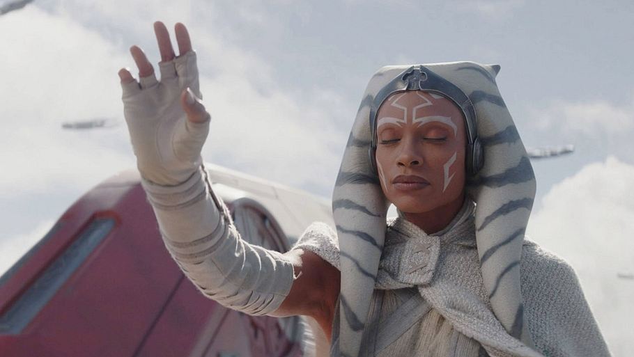 Ahsoka Tona hebt mit geschlossenen Augen die Hand. Sie trägt ein weißes Gewand. Im Hintergrund kann man Teile eines roten Raumschiffs erkennen.