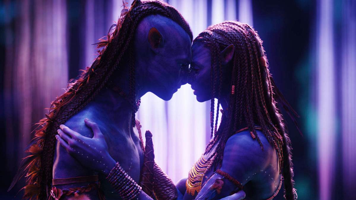 Man sieht Jake Sully und Neytiri als Na'vi in einem neon-lila Licht. Sie pressen ihre Nasen aneinander.