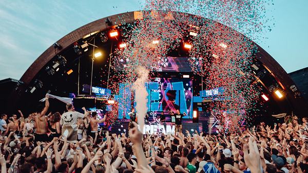 Man sieht eine große Menschenmasse auf dem „Germany goes Zrce“-Festival. Sie schießen vor der Bühne mit Konfetti.  - Foto: Martin Reitstätter