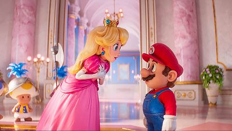 Peach (links) und Mario (rechts) stehen in einem Saal des Palastes des Pilzkönigreichs. Hinter Peach stehen drei Wachen, die Toads sind. - Foto: IMAGO / Capital Pictures