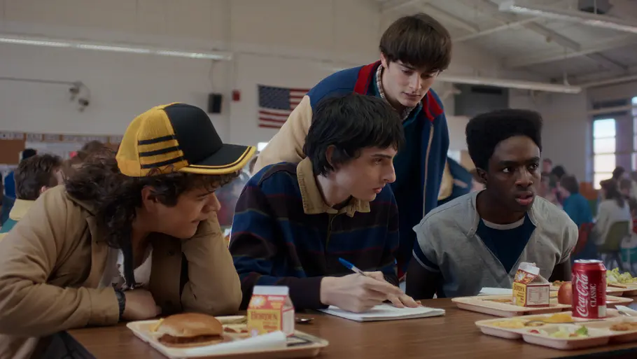 „Stranger Things“ Staffel 5 Gruppe von Jugendlichen sitzt am Kantinentisch.