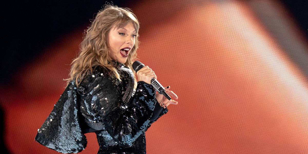 Taylor Swift während eines Konzertes mit schwarzer Glitzer-Jacke 