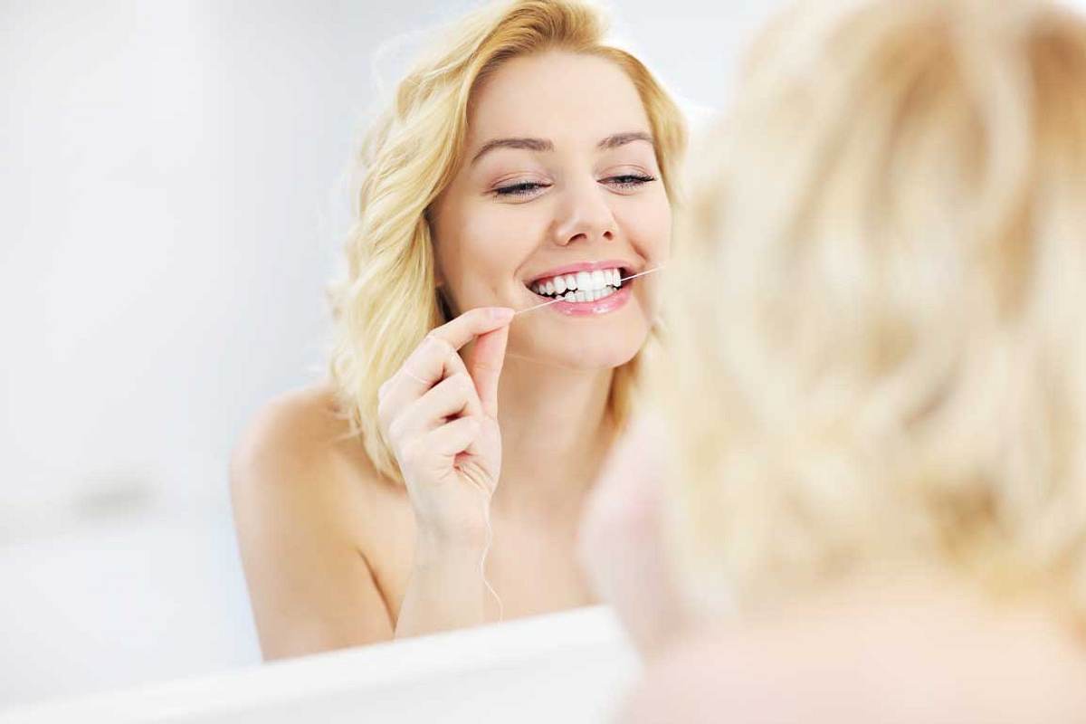 Tipps für schönere, weißere Zähne: Zahnseide verwenden